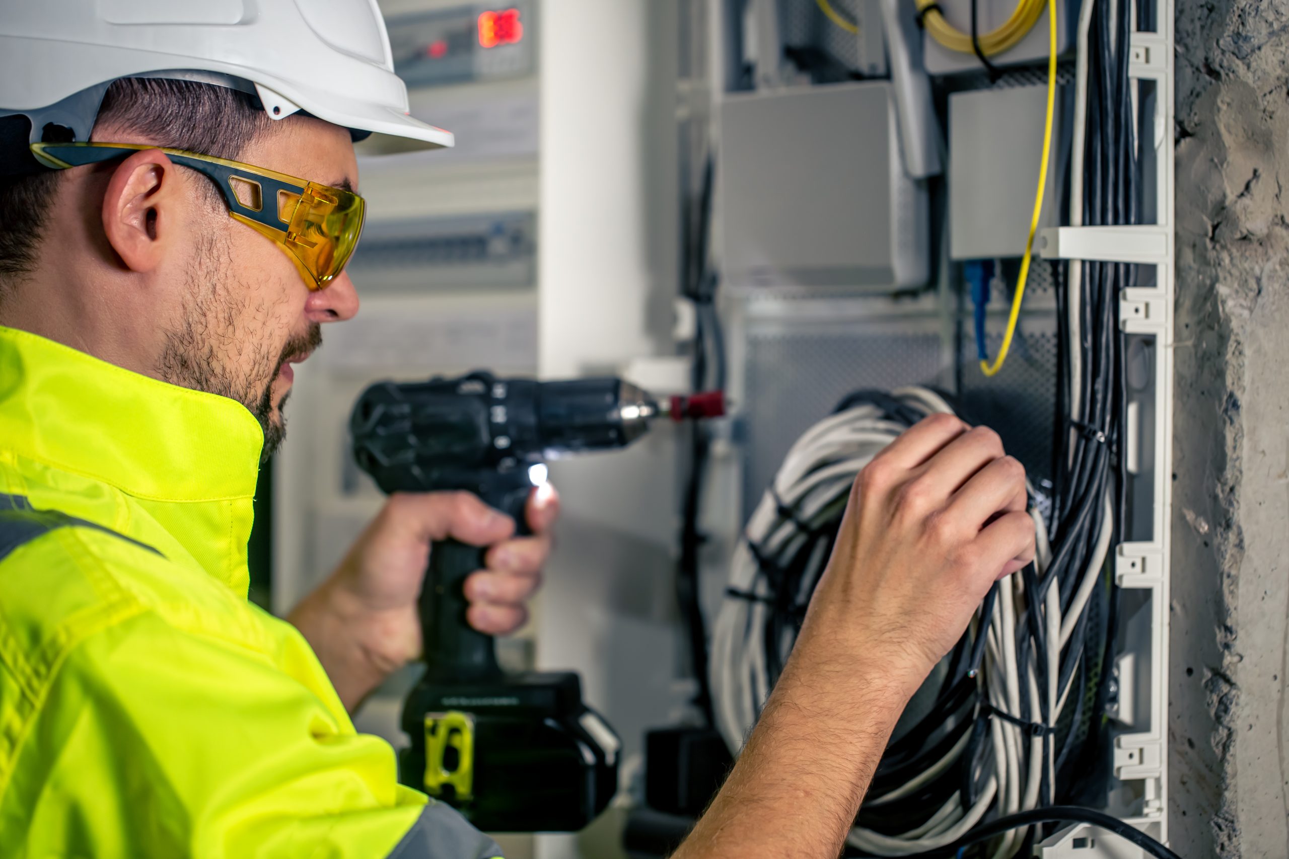 Man, an electrical technician working in a switchboard with fuses. ITPro - IT Solution Divi Child Theme Image 15